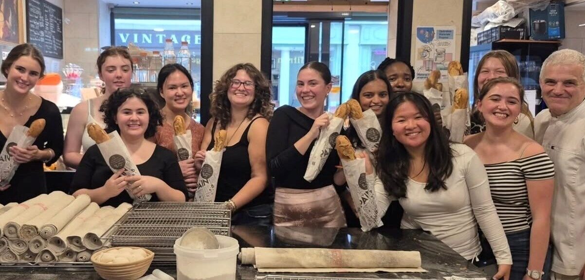 Group of students holding up bread from bread making class fall 2025