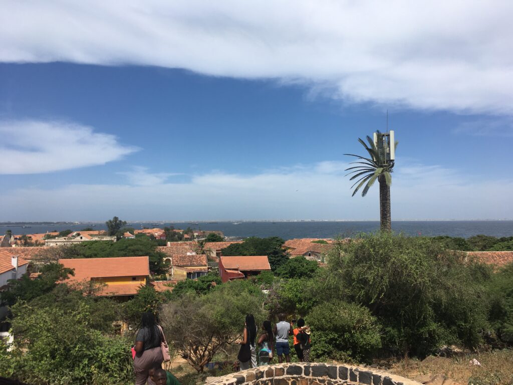 Hilltop view of low buildings, trees, and ocean