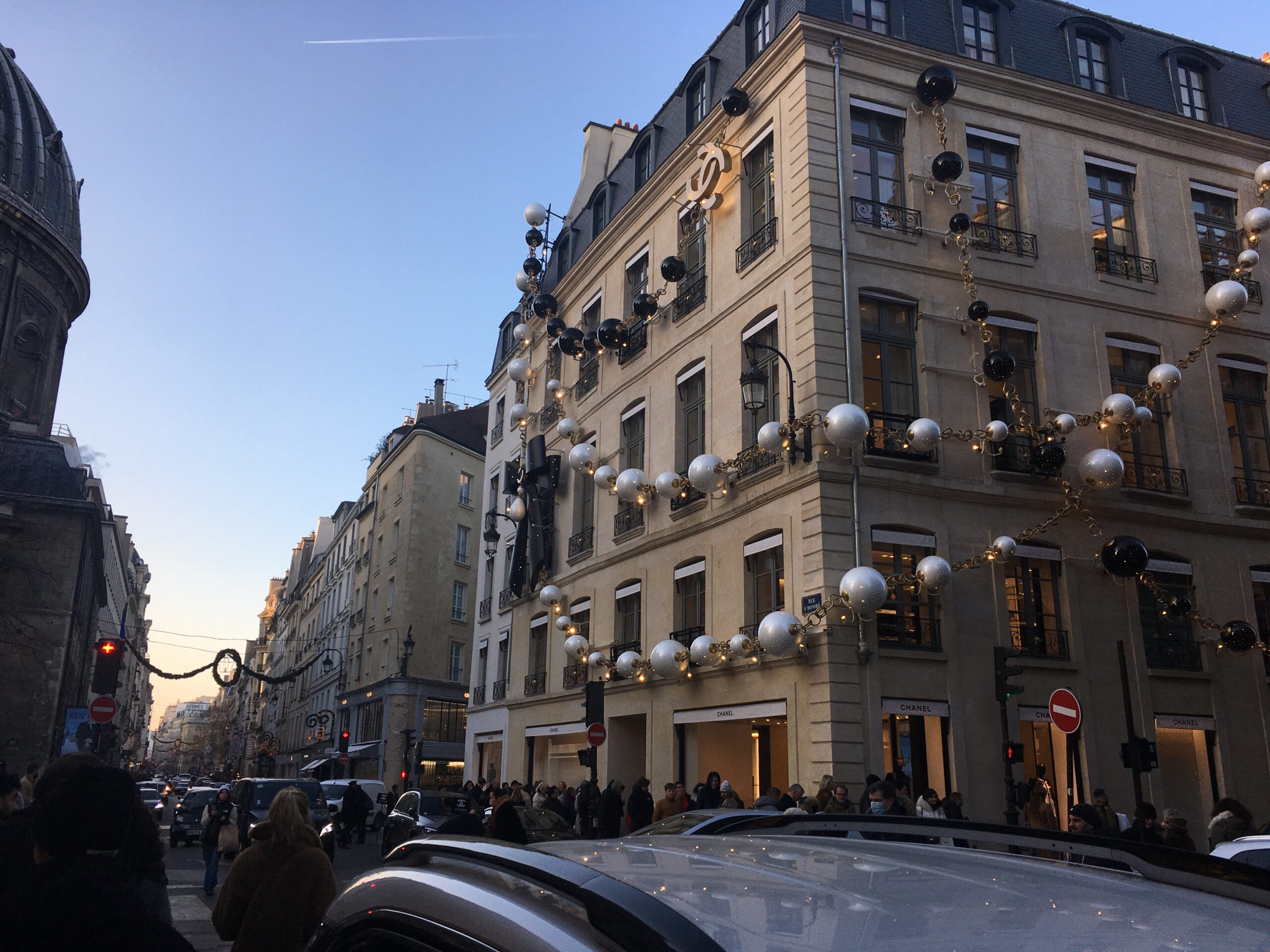 A street in Paris with a building covered in enormous Christmas garlands